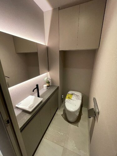 大きな鏡と独立手洗い器を備えたスタイリッシュなトイレ空間です!上部には扉付きの吊戸棚があり、トイレットペーパーや掃除用品を隠してスッキリ収納できますね♪ゲストも快適に利用できる上質な設備です! 大きな鏡と独立手洗い器を備えたスタイリッシュなトイレ空間です!上部には扉付きの吊戸棚があり、トイレットペーパーや掃除用品を隠してスッキリ収納できますね♪ゲストも快適に利用できる上質な設備です!