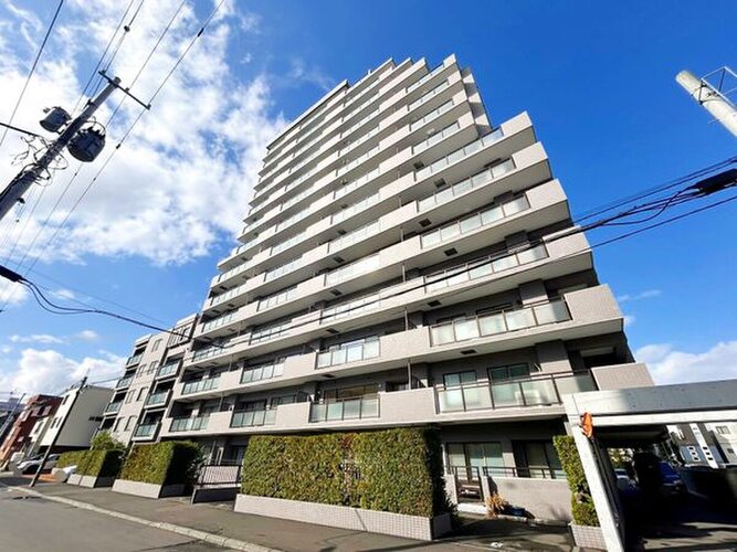 青空に映えるスタイリッシュで重厚感のあるマンション外観です！周辺は落ち着いた街並みとなっており、毎日の通勤や通学はもちろん休日のお出かけからご帰宅された際にも安心感を与えてくれる佇まいです