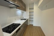 調理スペースをしっかり確保した3口コンロ付きのシステムキッチン！奥には便利な収納棚を備えており、調味料や調理器具もすっきり整理できます。毎日の料理や後片付けがはかどる機能的な設計です！