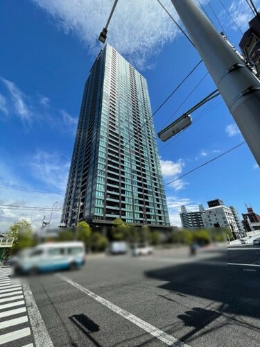 すっきりと晴れ渡る青空に映える見上げるほどのタワーマンションです！見通しの良い広い交差点に面しており、陽当たりや風通しも期待できます♪おでかけや通勤通学の際も気持ちよく出発できますね！